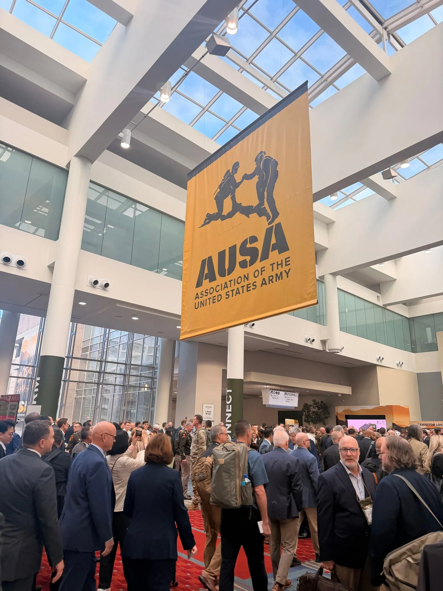 The AUSA banner hanging over a crowd of attendees in suits and uniforms at the Walter E. Washington Convention Center